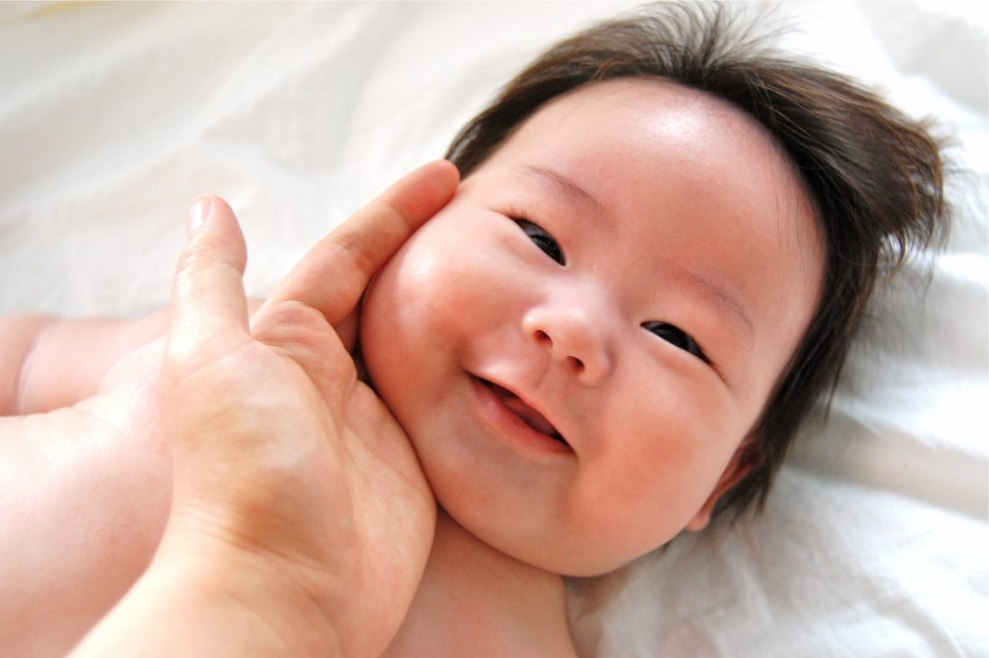 赤ちゃんのほっぺたを触っている写真